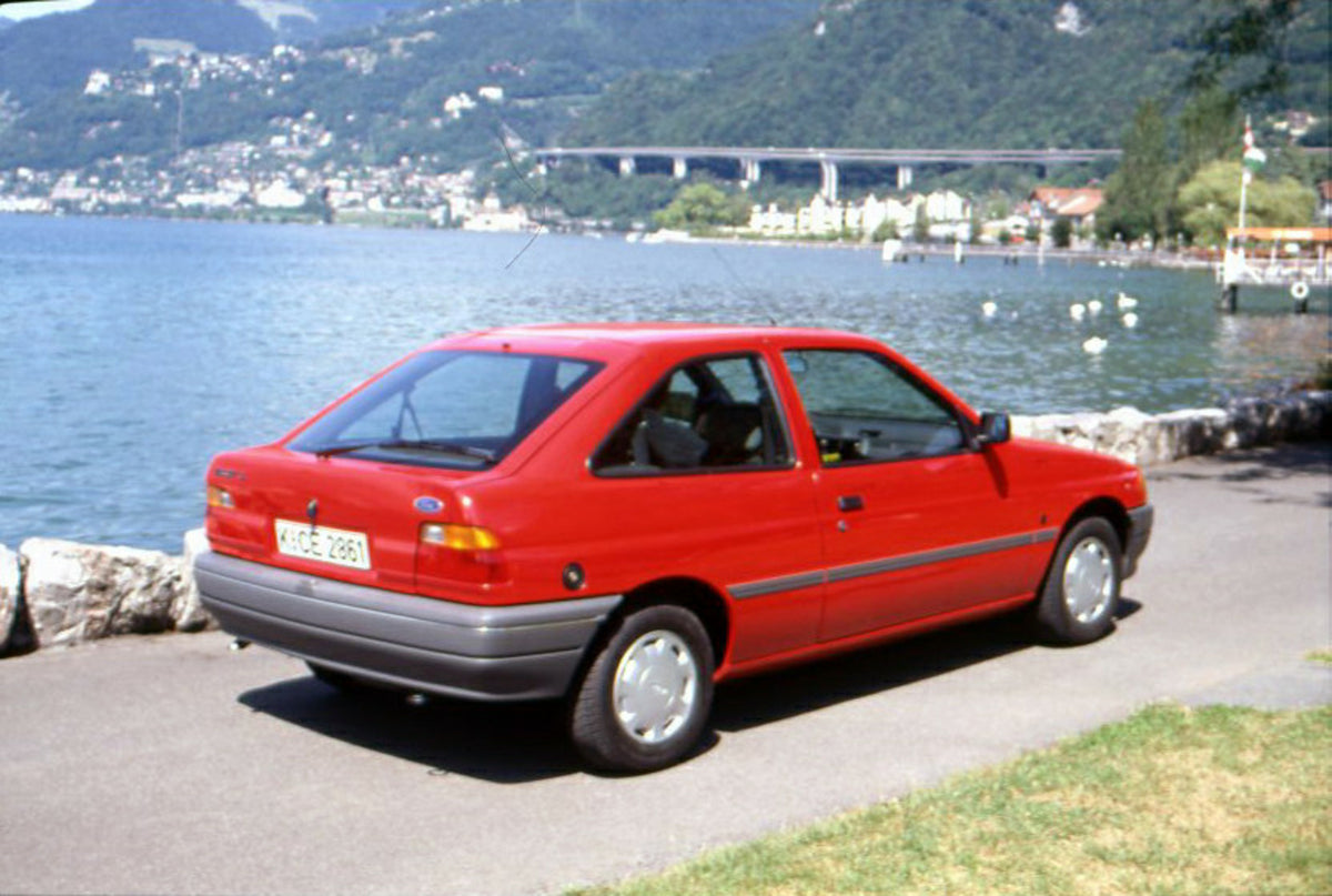 This archival image documents the 1990 Ford Escort CL Mark IV on scenic road in Geneva, Switzerland and is preserved in the Ford Heritage Vault as part of Ford Motor Company's historic photographic archive. Free for personal, non-commercial use. F...