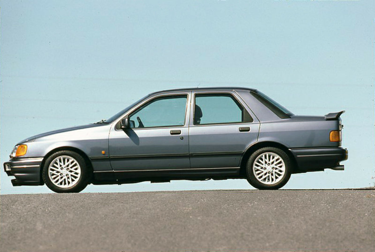 This archival image documents the 1987 Ford Sierra RS Cosworth side view with scenic blue sky and is preserved in the Ford Heritage Vault as part of Ford Motor Company's historic photographic archive. Free for personal, non-commercial use. Ford He...