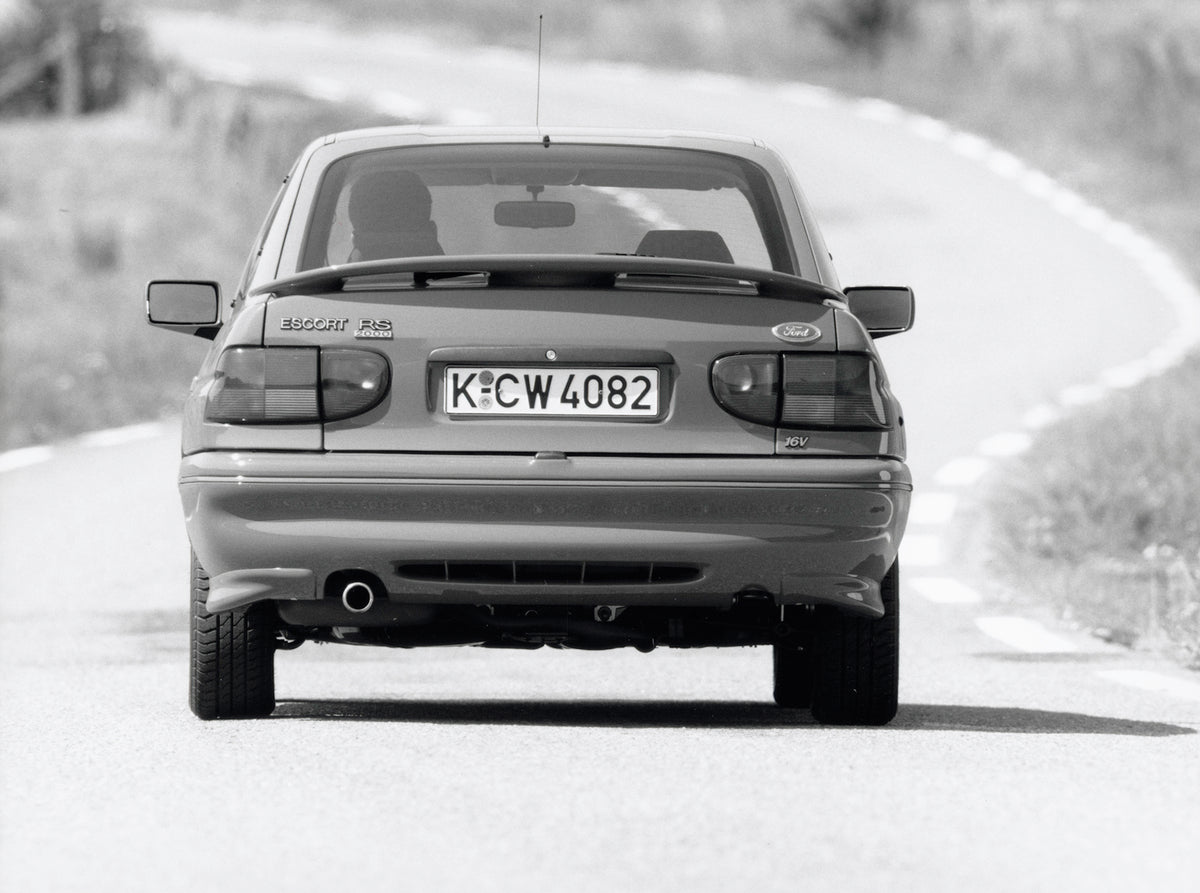This archival image documents the 1993 Ford Escort Mark V RS2000 rear view on scenic road and is preserved in the Ford Heritage Vault as part of Ford Motor Company's historic photographic archive. Free for personal, non-commercial use. Ford Herita...