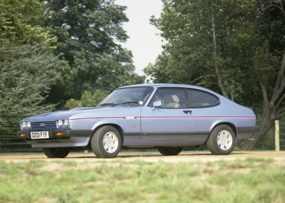 This archival image documents the 1986 Ford Capri Mark III low view with scenic trees 1986-746 64 and is preserved in the Ford Heritage Vault as part of Ford Motor Company's historic photographic archive. Free for personal, non-commercial use. For...