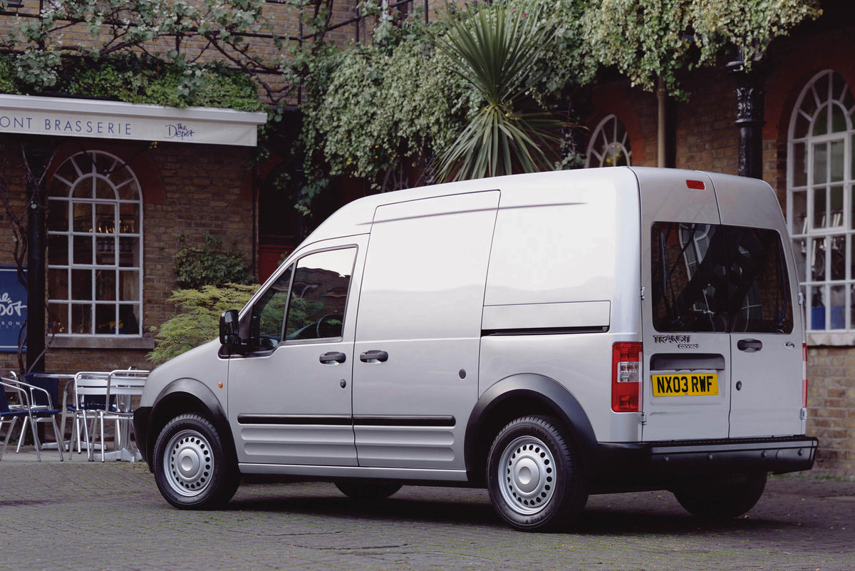 This archival image documents the 2003 Ford Transit Connect rear view in front of scenic café and is preserved in the Ford Heritage Vault as part of Ford Motor Company's historic photographic archive. Free for personal, non-commercial use. Ford He...