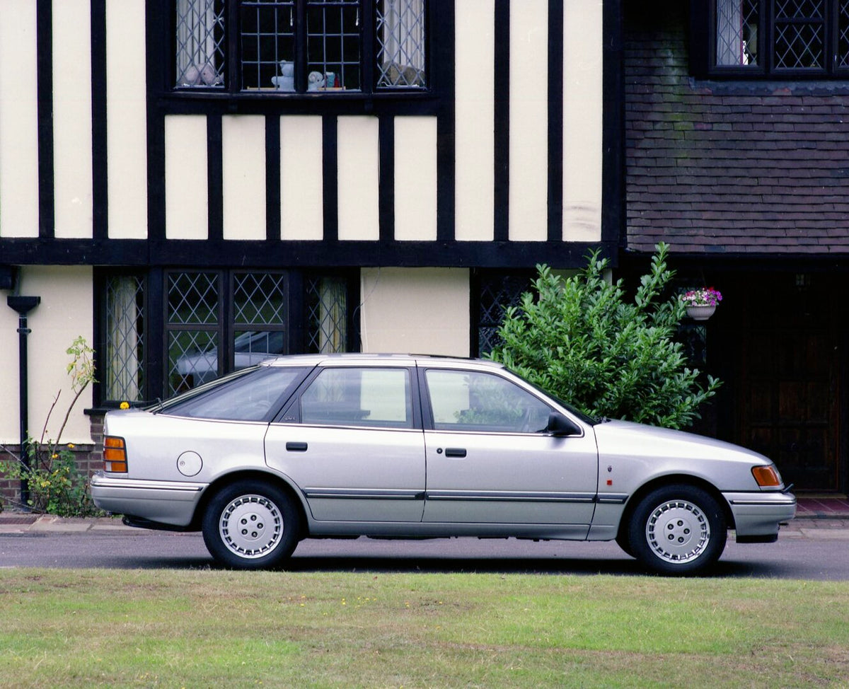 This archival image documents the 1990 Ford Granada MK III Ghia X side view in front of scenic house and is preserved in the Ford Heritage Vault as part of Ford Motor Company's historic photographic archive. Free for personal, non-commercial use. ...