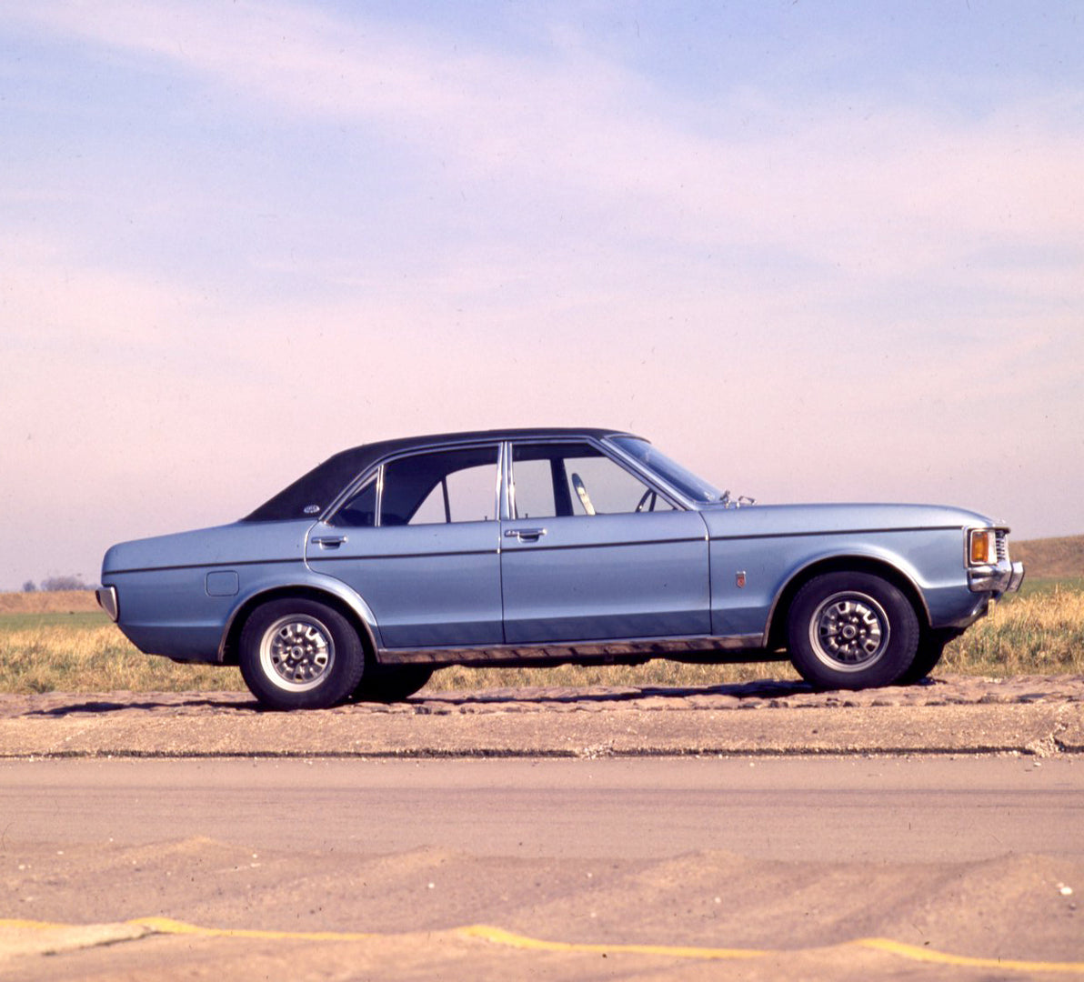 This archival image documents the 1977 Ford Granada Mark I side view on scenic road and is preserved in the Ford Heritage Vault as part of Ford Motor Company's historic photographic archive. Free for personal, non-commercial use. Ford Heritage Vau...
