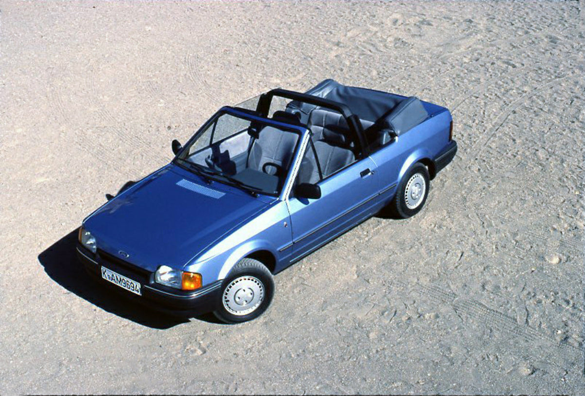 This archival image documents the 1986 Ford Escort Mark IV Cabriolet aerial view on scenic beach and is preserved in the Ford Heritage Vault as part of Ford Motor Company's historic photographic archive. Free for personal, non-commercial use. Ford...