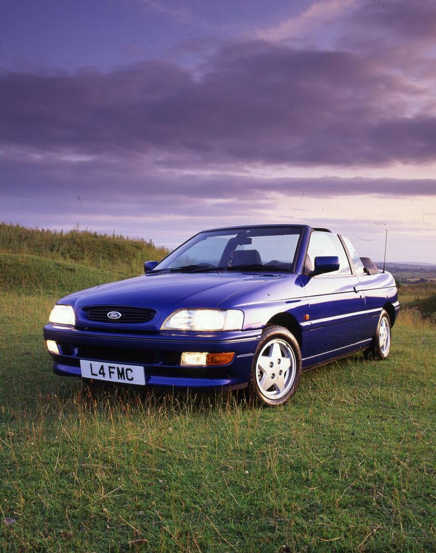 This archival image documents the 1993 Ford Escort Mark V Cabriolet in scenic field and is preserved in the Ford Heritage Vault as part of Ford Motor Company's historic photographic archive. Free for personal, non-commercial use. Ford Heritage Vau...