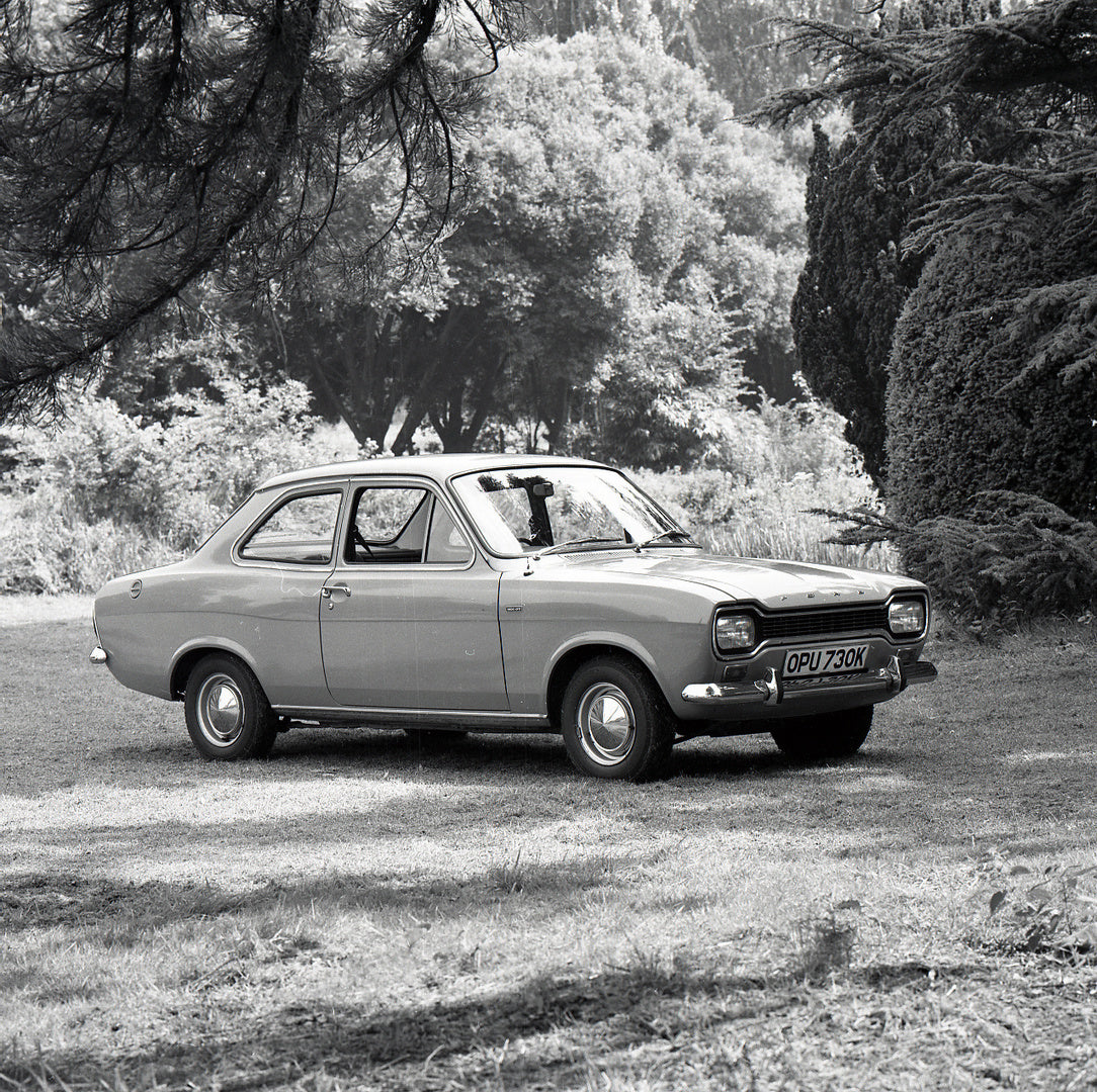 This archival image documents the 1971 Ford Escort Mark I 1300 GT 2 Door with scenic trees and is preserved in the Ford Heritage Vault as part of Ford Motor Company's historic photographic archive. Free for personal, non-commercial use. Ford Herit...