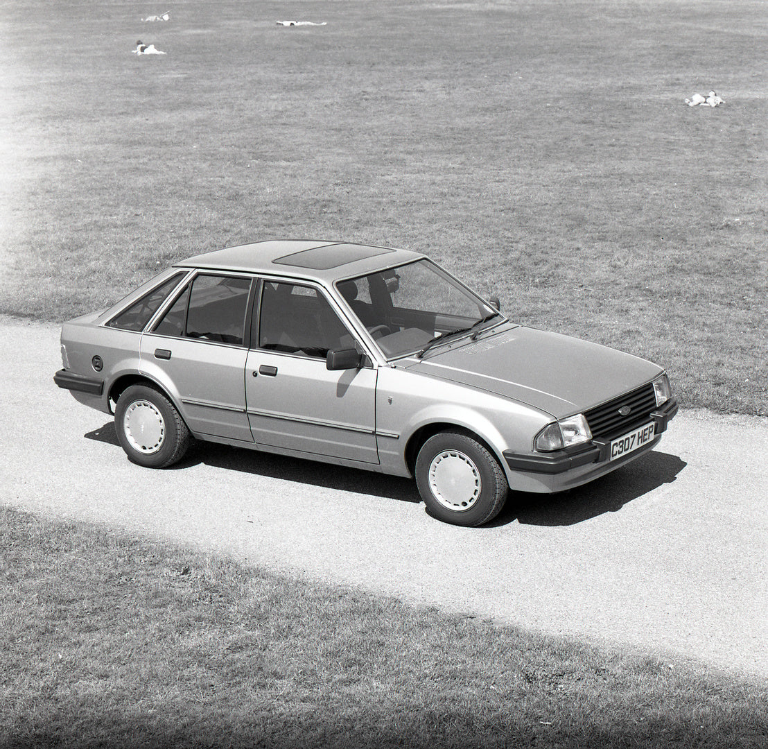This archival image documents the 1985 Ford Escort Mark III Ghia aerial view on scenic road in field and is preserved in the Ford Heritage Vault as part of Ford Motor Company's historic photographic archive. Free for personal, non-commercial use. ...