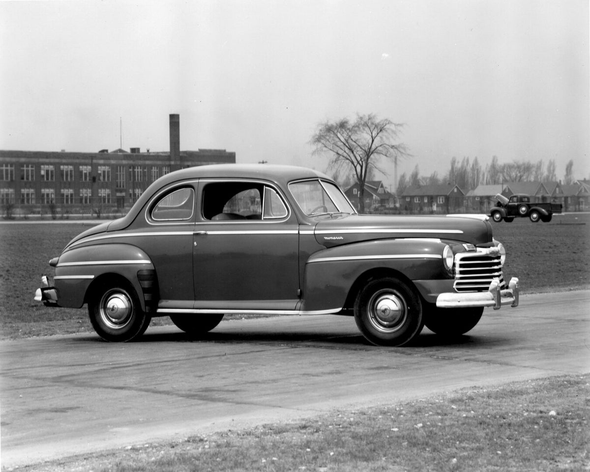 This archival image documents the 1946 Monarch Coupe on road in front of building AR-2007-5 and is preserved in the Ford Heritage Vault as part of Ford Motor Company's historic photographic archive. Free for personal, non-commercial use. Ford Heri...