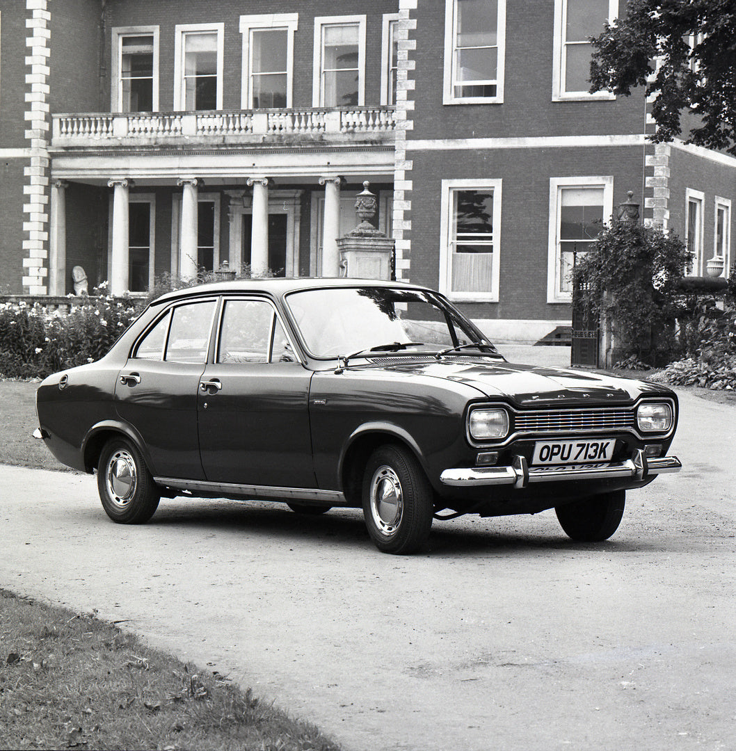 This archival image documents the 1971 Ford Escort Mark I 1300 XL 4 Door in front of scenic house with flowers and shrubs and is preserved in the Ford Heritage Vault as part of Ford Motor Company's historic photographic archive. Free for personal,...