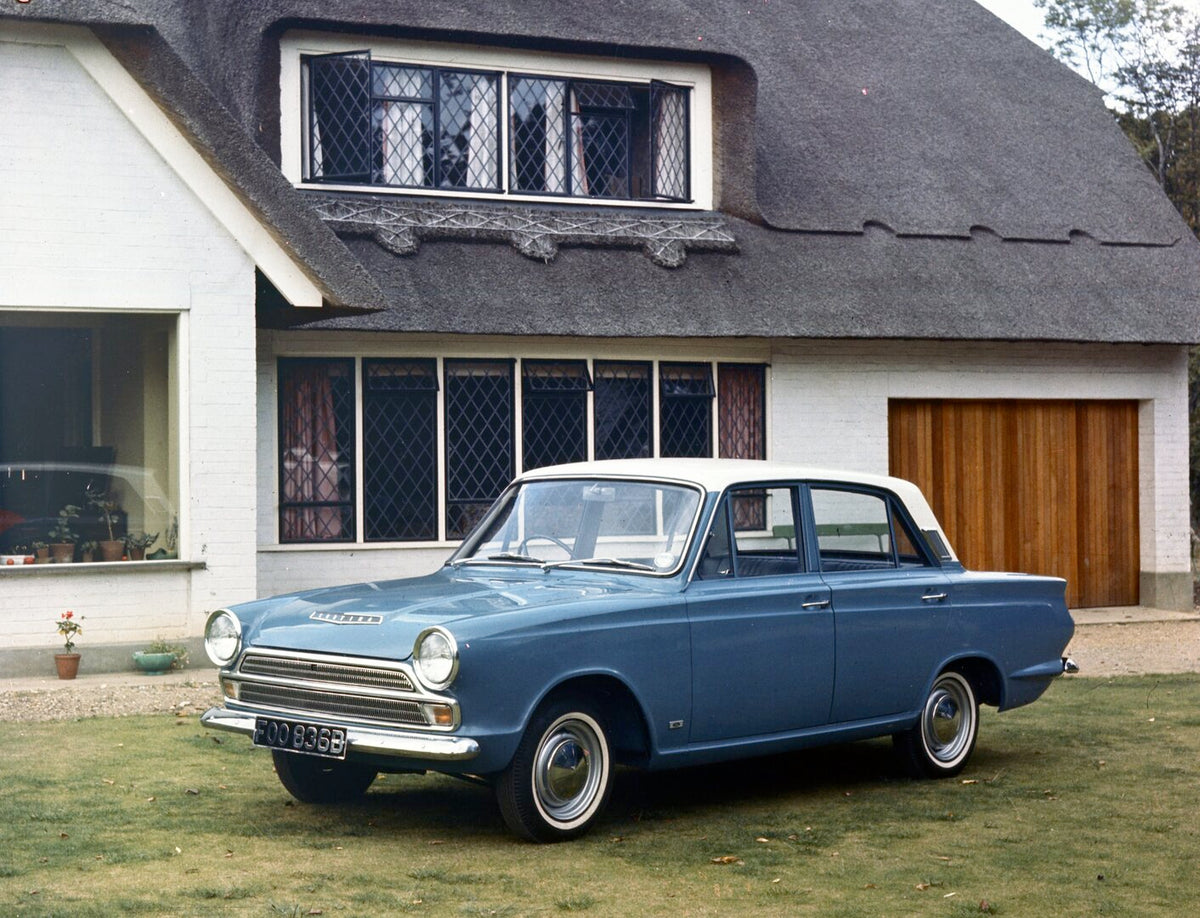 This archival image documents the 1964 Ford Cortina MK I DeLux in front of scenic house and is preserved in the Ford Heritage Vault as part of Ford Motor Company's historic photographic archive. Free for personal, non-commercial use. Ford Heritage...