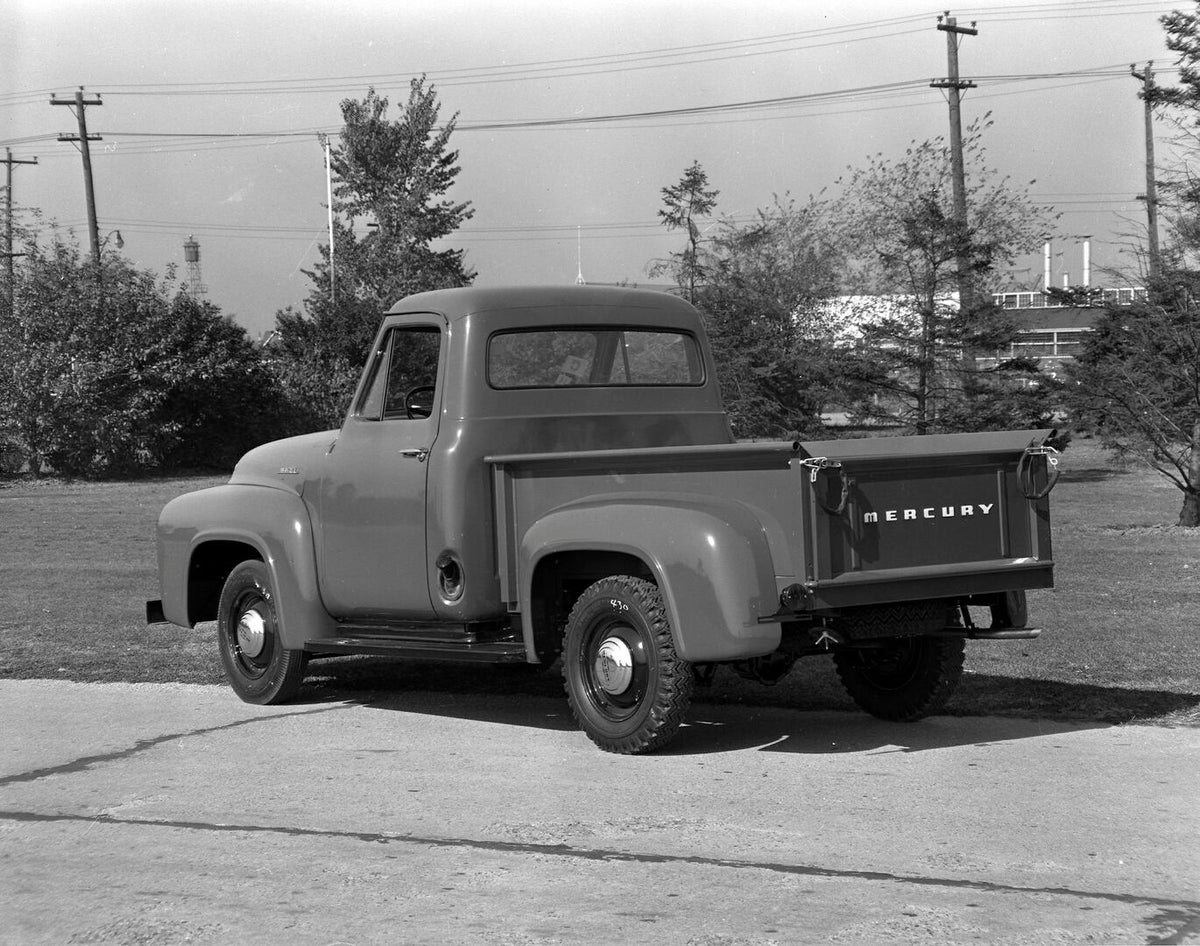 This archival image documents the 1953 Mercury M-100 Pickup rear view on scenic road AR-2007-5 and is preserved in the Ford Heritage Vault as part of Ford Motor Company's historic photographic archive. Free for personal, non-commercial use. Ford H...