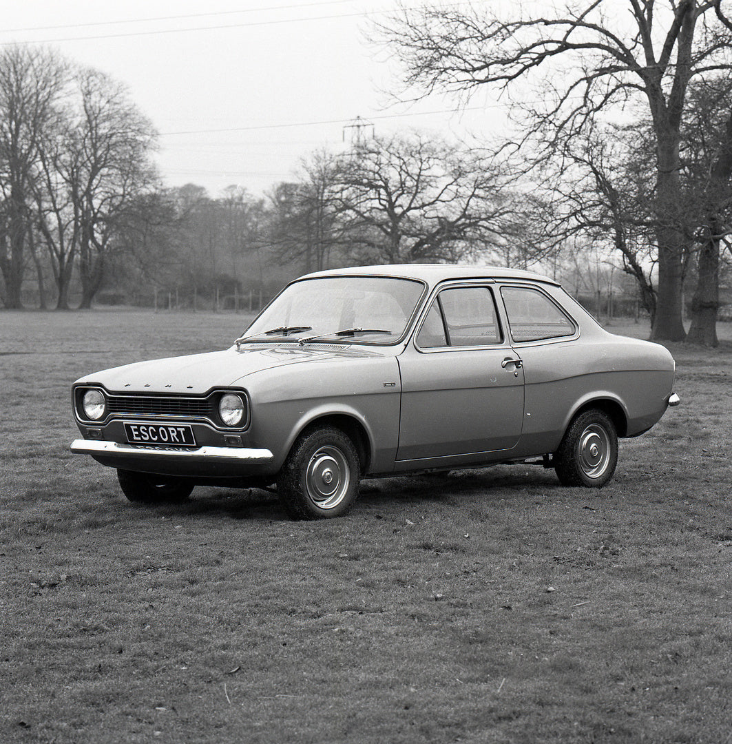 This archival image documents the 1974 Ford Escort Mark I L 1300 2 Door in scenic field with trees and is preserved in the Ford Heritage Vault as part of Ford Motor Company's historic photographic archive. Free for personal, non-commercial use. Fo...