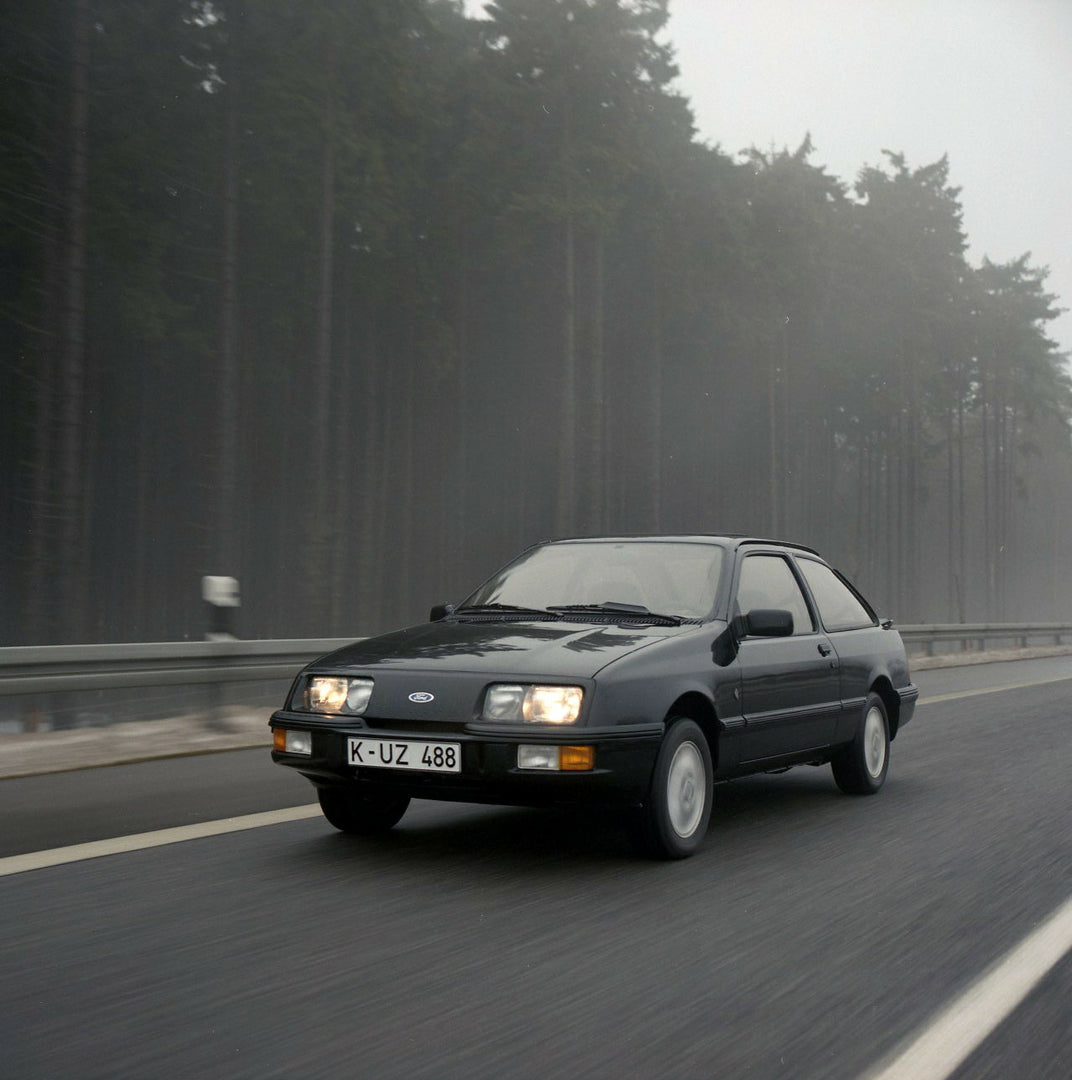 This archival image documents the 1985 Ford Sierra XR 4x4 LHD action shot on scenic road with trees and is preserved in the Ford Heritage Vault as part of Ford Motor Company's historic photographic archive. Free for personal, non-commercial use. F...