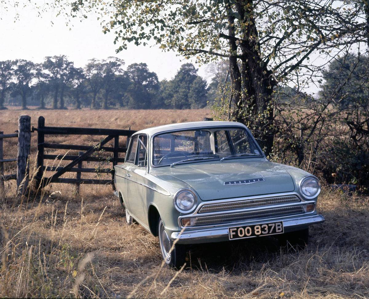 This archival image documents the 1964 Ford Cortina Super MK I in scenic field with trees and is preserved in the Ford Heritage Vault as part of Ford Motor Company's historic photographic archive. Free for personal, non-commercial use. Ford Herita...
