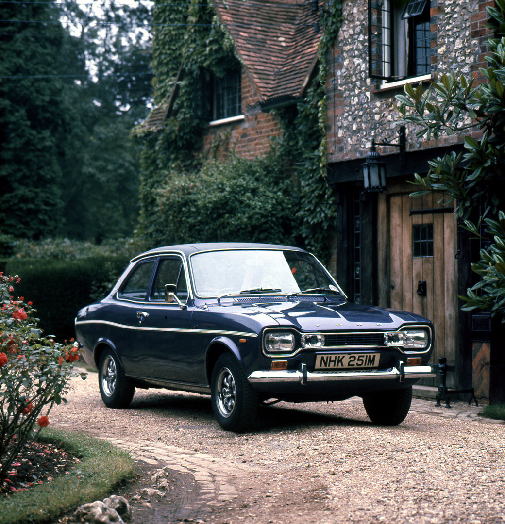 This archival image documents the 1973 Ford Escort Mark I 1300 E 2 Door in front of scenic house and is preserved in the Ford Heritage Vault as part of Ford Motor Company's historic photographic archive. Free for personal, non-commercial use. Ford...