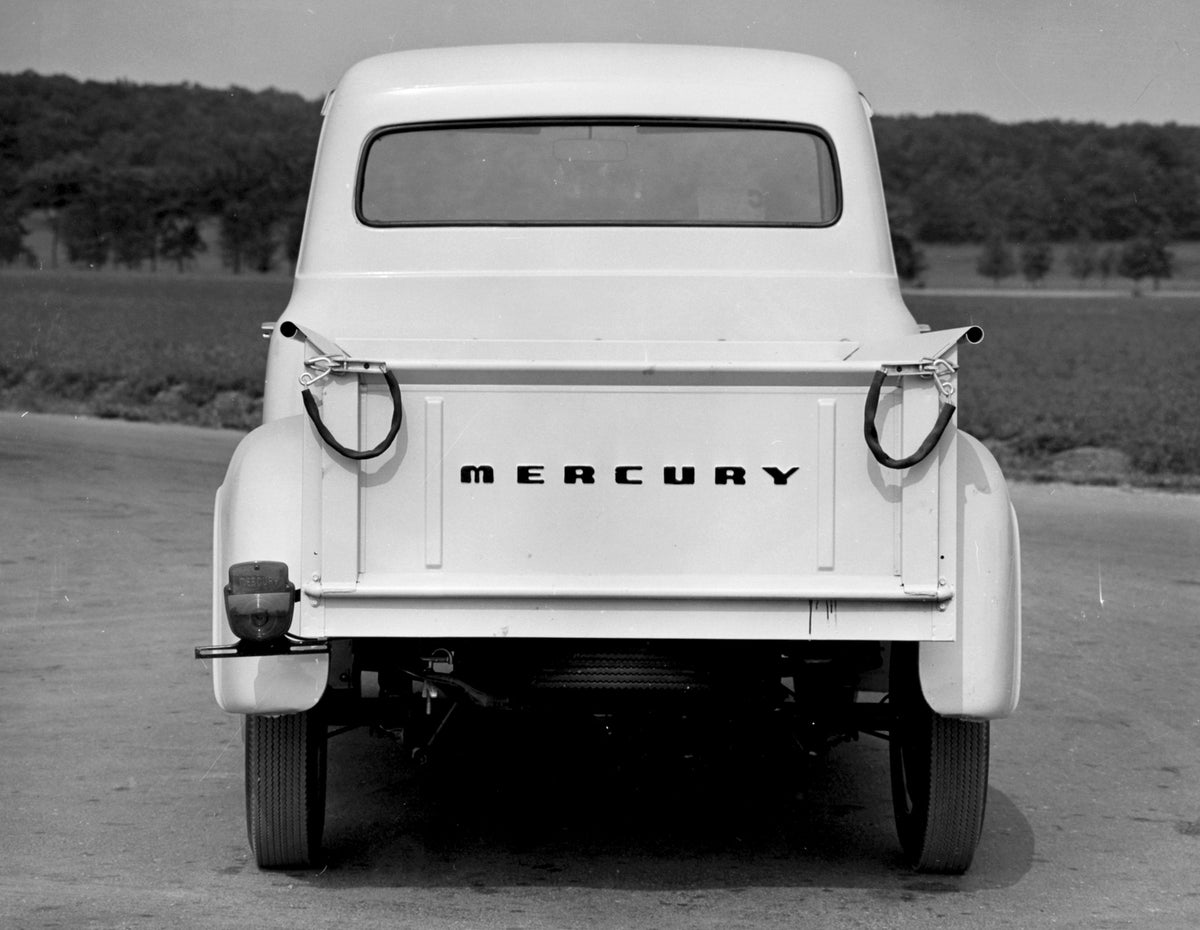 This archival image documents the 1955 Mercury M-100 Pickup rear view on scenic road AR-2007-5 and is preserved in the Ford Heritage Vault as part of Ford Motor Company's historic photographic archive. Free for personal, non-commercial use. Ford H...