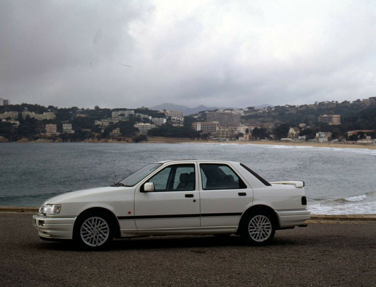 This archival image documents the 1990 Ford Sierra 90.5 LHD side view on scenic beach in Spain and is preserved in the Ford Heritage Vault as part of Ford Motor Company's historic photographic archive. Free for personal, non-commercial use. Ford H...