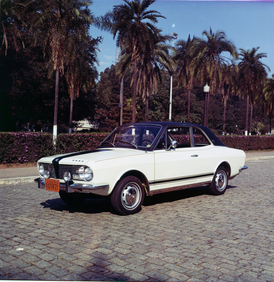 This archival image documents the 1970 Ford Corcel two-door on scenic road with palm trees and is preserved in the Ford Heritage Vault as part of Ford Motor Company's historic photographic archive. Free for personal, non-commercial use. Ford Herit...
