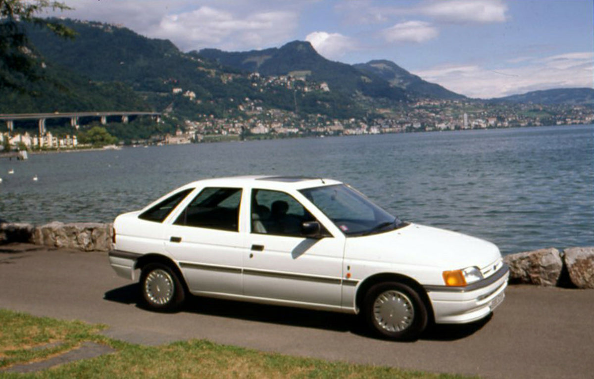 This archival image documents the 1990 Ford Escort Ghia Mark IV on scenic road in Geneva, Switzerland and is preserved in the Ford Heritage Vault as part of Ford Motor Company's historic photographic archive. Free for personal, non-commercial use....