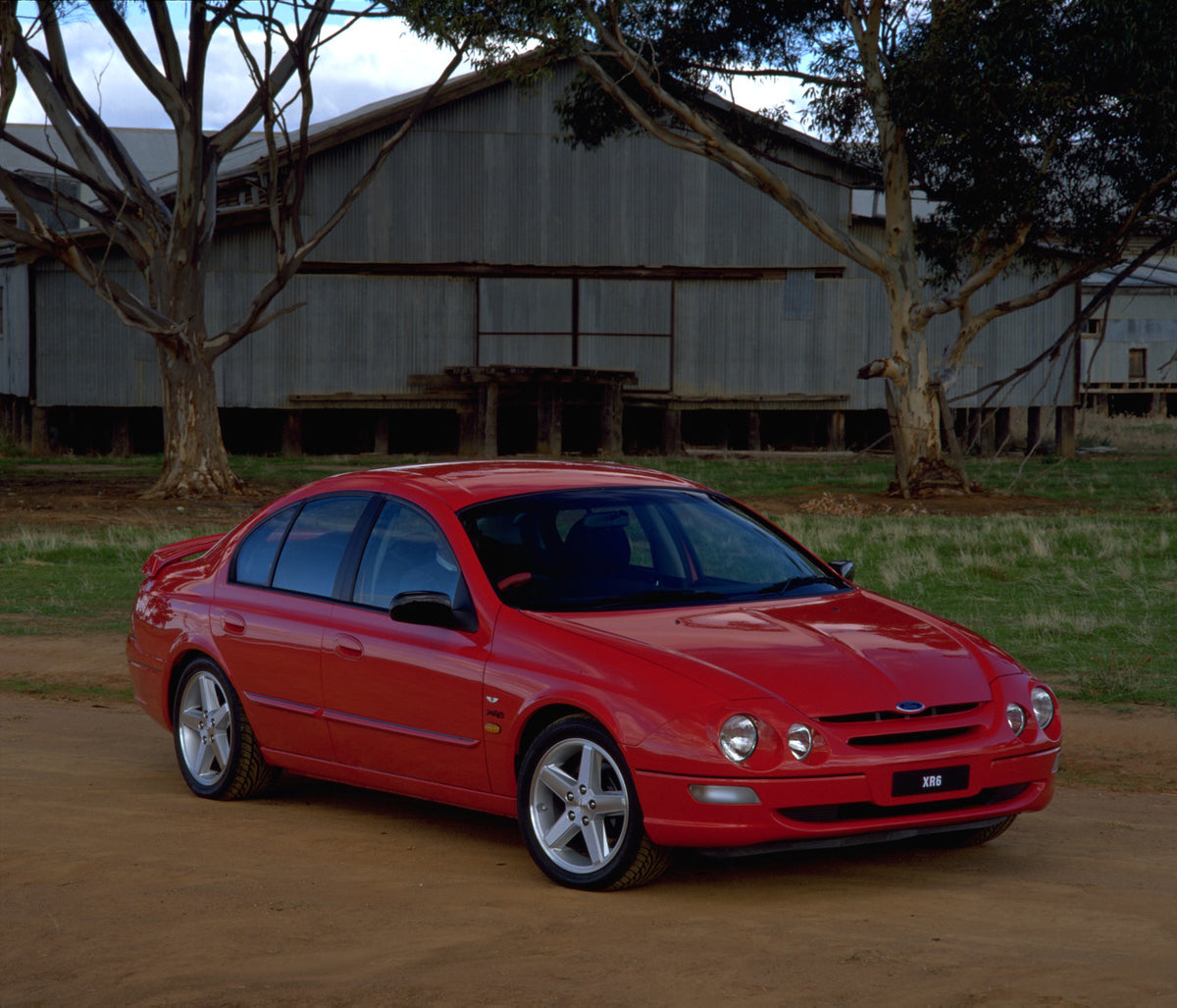This archival image documents the 1998 Ford Falcon XR6 on dirt road with scenic barn and is preserved in the Ford Heritage Vault as part of Ford Motor Company's historic photographic archive. Free for personal, non-commercial use. Ford Heritage Va...