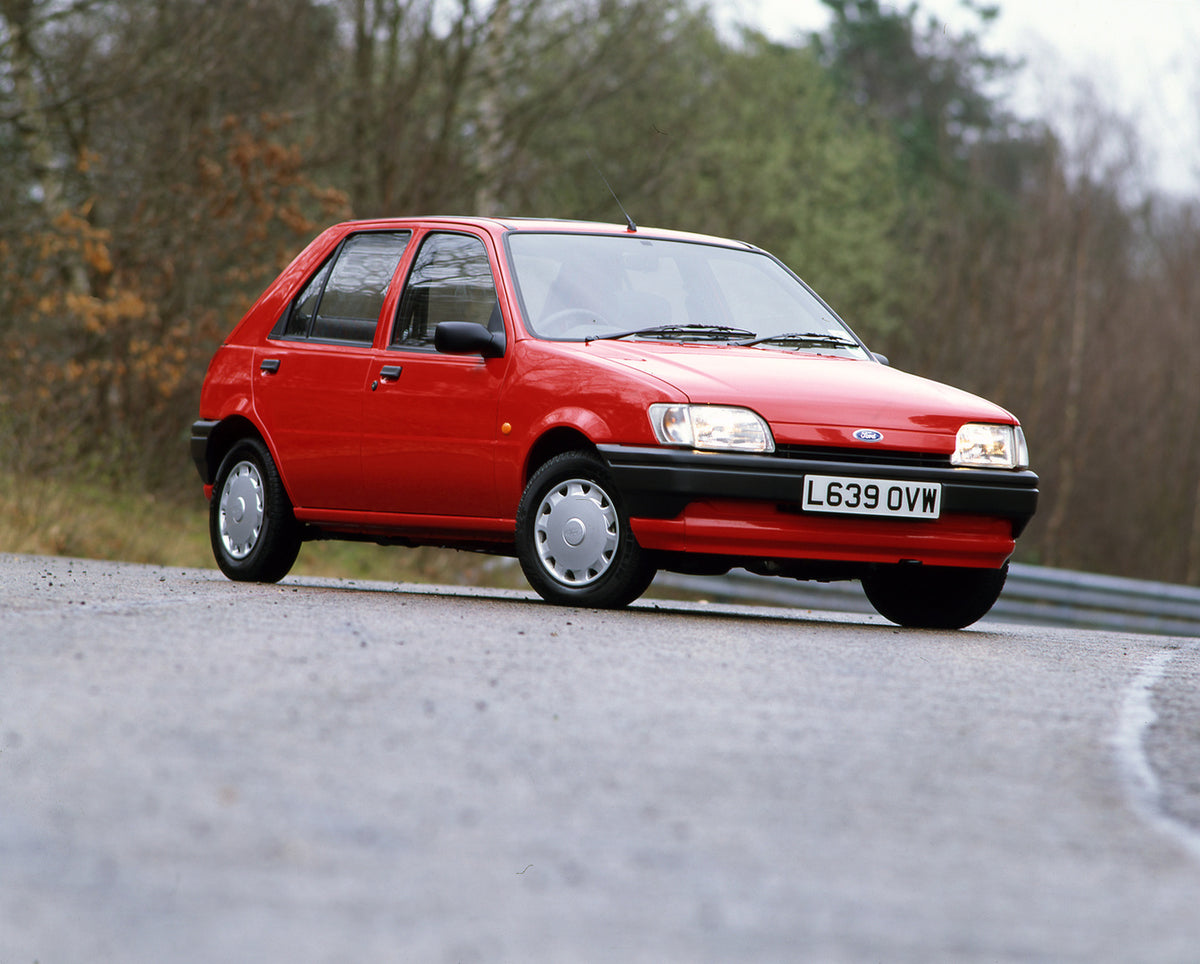 This archival image documents the 1994 Ford Fiesta Mark IV on scenic road with trees and is preserved in the Ford Heritage Vault as part of Ford Motor Company's historic photographic archive. Free for personal, non-commercial use. Ford Heritage Va...