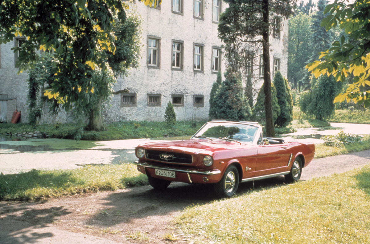 This archival image documents the 1965 Ford Mustang on scenic road with trees and is preserved in the Ford Heritage Vault as part of Ford Motor Company's historic photographic archive. Free for personal, non-commercial use. Ford Heritage Vault ref...