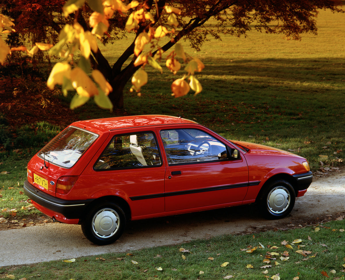 This archival image documents the 1990 Ford Fiesta Mark III Popular Plus side view with scenic autumn trees and is preserved in the Ford Heritage Vault as part of Ford Motor Company's historic photographic archive. Free for personal, non-commercia...