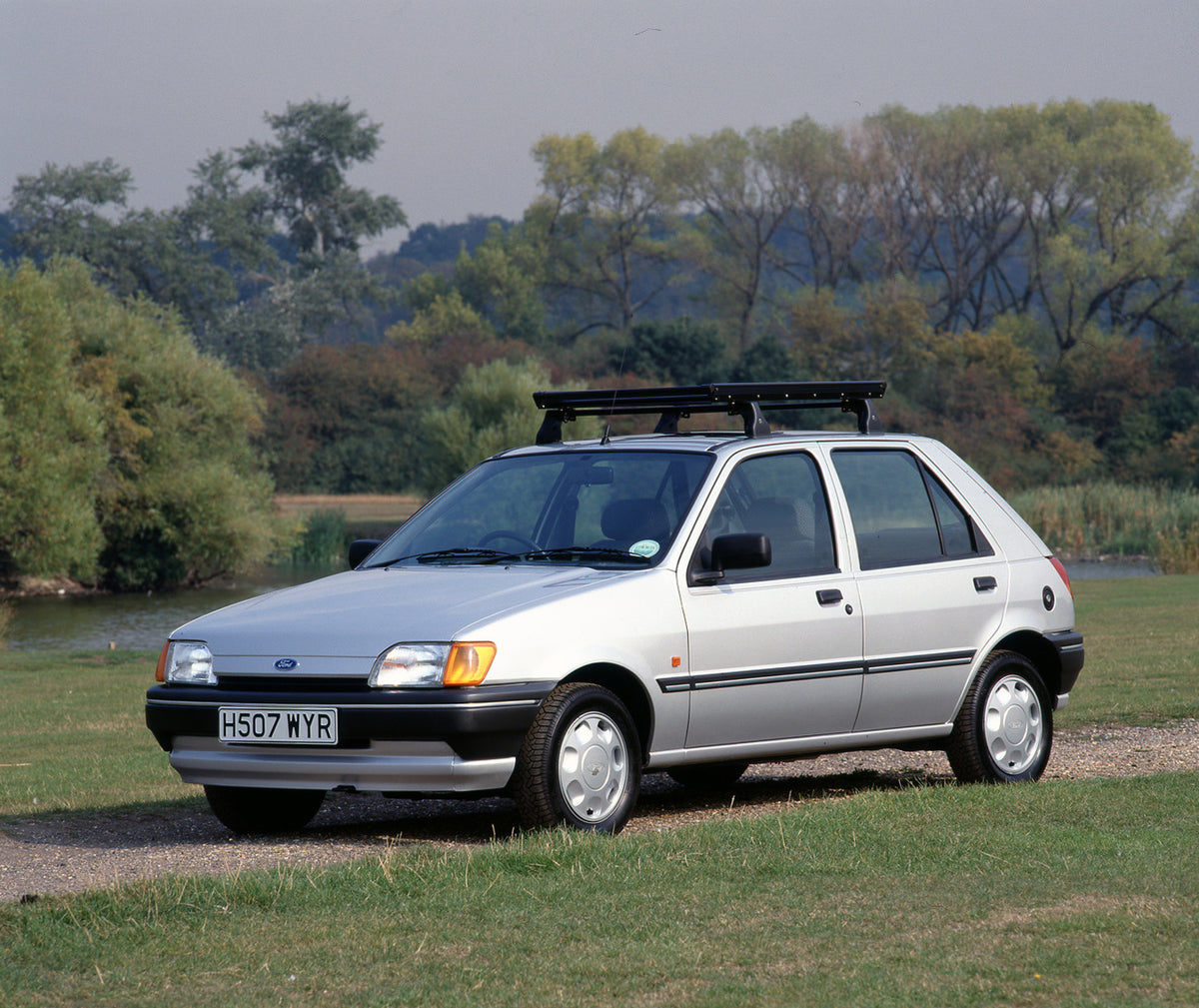 This archival image documents the 1990 Ford Fiesta Mark III LX on scenic path near lake with roof rack and is preserved in the Ford Heritage Vault as part of Ford Motor Company's historic photographic archive. Free for personal, non-commercial use...