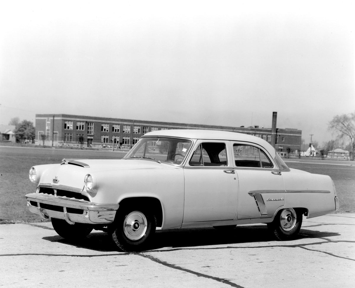 This archival image documents the 1952 Monarch Sedan on road with building AR-2007-5 and is preserved in the Ford Heritage Vault as part of Ford Motor Company's historic photographic archive. Free for personal, non-commercial use. Ford Heritage Va...