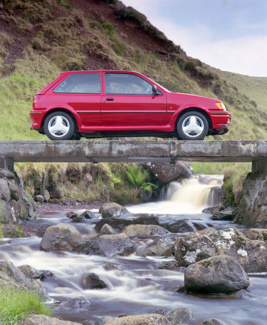 This archival image documents the 1990 Ford Fiesta Mark III Turbo on scenic bridge over river in Northern Ireland and is preserved in the Ford Heritage Vault as part of Ford Motor Company's historic photographic archive. Free for personal, non-com...