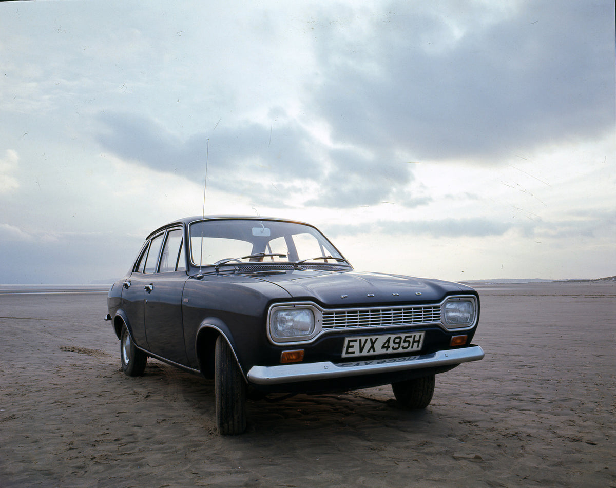 This archival image documents the 1970 Ford Escort Mark I on scenic beach and is preserved in the Ford Heritage Vault as part of Ford Motor Company's historic photographic archive. Free for personal, non-commercial use. Ford Heritage Vault referen...