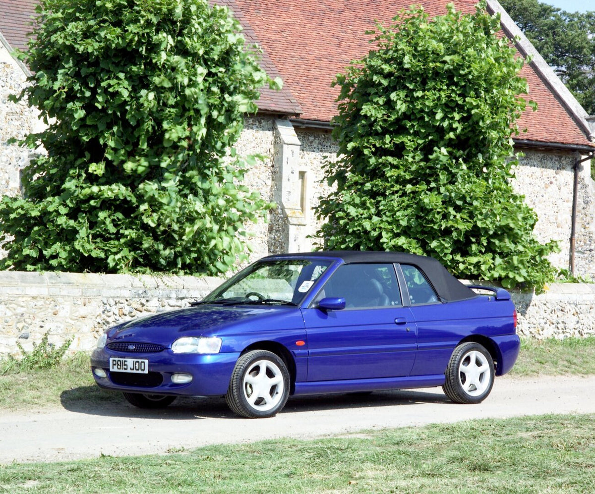This archival image documents the 1996 Ford Escort Mark VI Cabriolet Ghia in front of scenic building with top up and is preserved in the Ford Heritage Vault as part of Ford Motor Company's historic photographic archive. Free for personal, non-com...