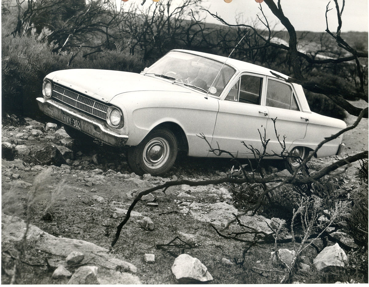 This archival image documents the 1964 Ford XM Falcon on scenic rocky road with trees and is preserved in the Ford Heritage Vault as part of Ford Motor Company's historic photographic archive. Free for personal, non-commercial use. Ford Heritage V...