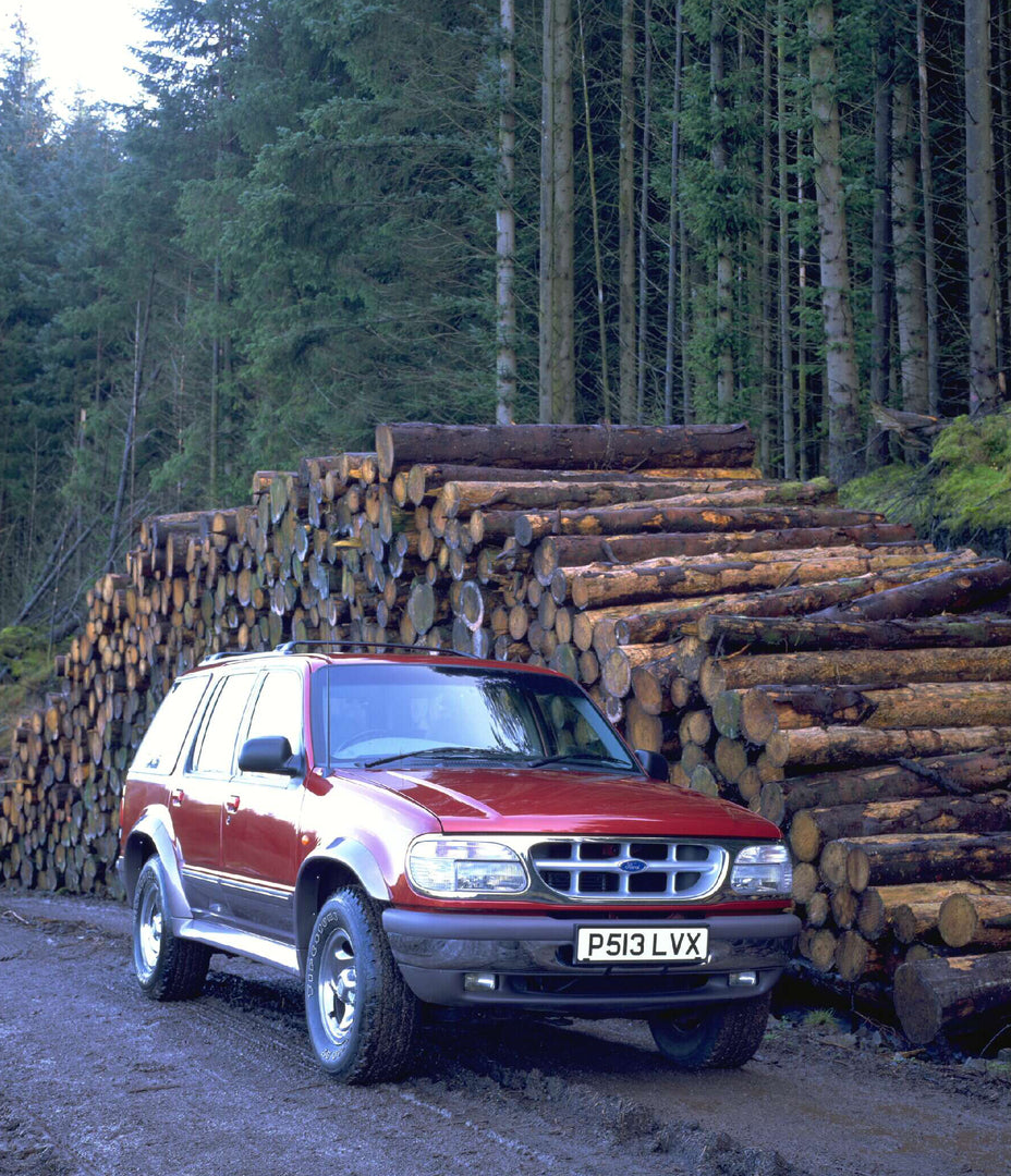 This archival image documents the 1996 Ford Explorer on scenic forest road with logs AR-2002-213709 and is preserved in the Ford Heritage Vault as part of Ford Motor Company's historic photographic archive. Free for personal, non-commercial use. F...