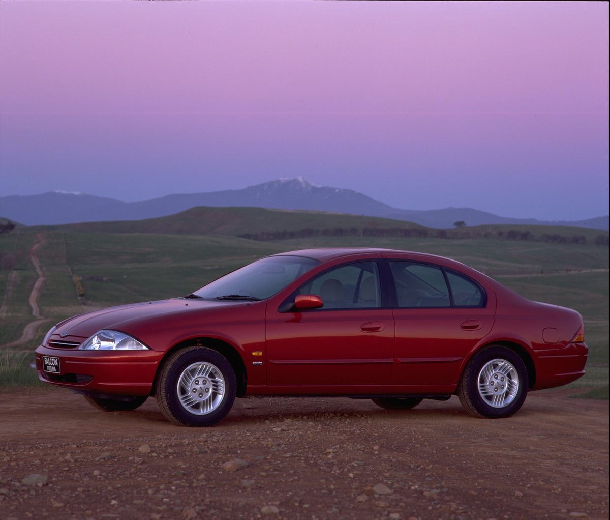 This archival image documents the 1998 Ford Falcon Futura side view on scenic road with mountains and is preserved in the Ford Heritage Vault as part of Ford Motor Company's historic photographic archive. Free for personal, non-commercial use. For...