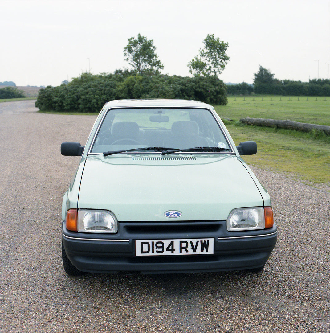 This archival image documents the 1987 Ford Escort Mark IV Ghia 1.6 front view on scenic road and is preserved in the Ford Heritage Vault as part of Ford Motor Company's historic photographic archive. Free for personal, non-commercial use. Ford He...