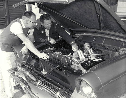 1956 NASCAR Daytona Beach Speed Weeks Florida Vern Houle, Driver and Mechanic for Bill Stroppe Racing, points to the carburetors on the highly modified 391 cid Lincoln V8 0144-0715