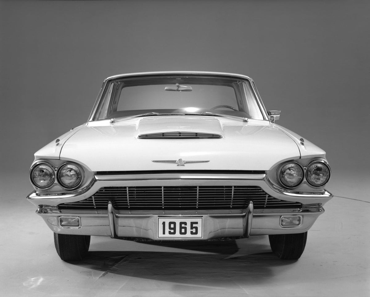 A 1965 Ford Thunderbird hardtop is photographed directly from the front in a studio.