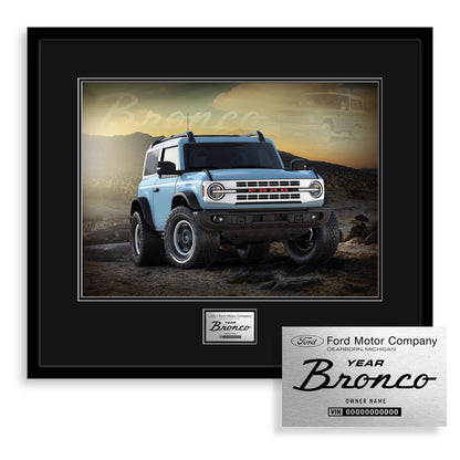 Framed photo of a blue Ford Bronco SUV with a desert background, featuring the Ford Motor Company logo.