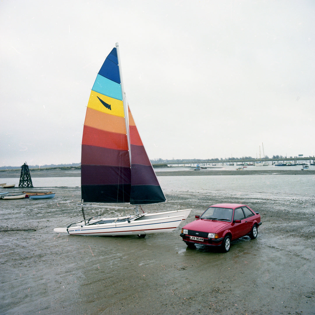 This archival image documents the 1980 Ford Escort Mark III XR3 and Collapsible Boats on scenic beach and is preserved in the Ford Heritage Vault as part of Ford Motor Company's historic photographic archive. Free for personal, non-commercial use....