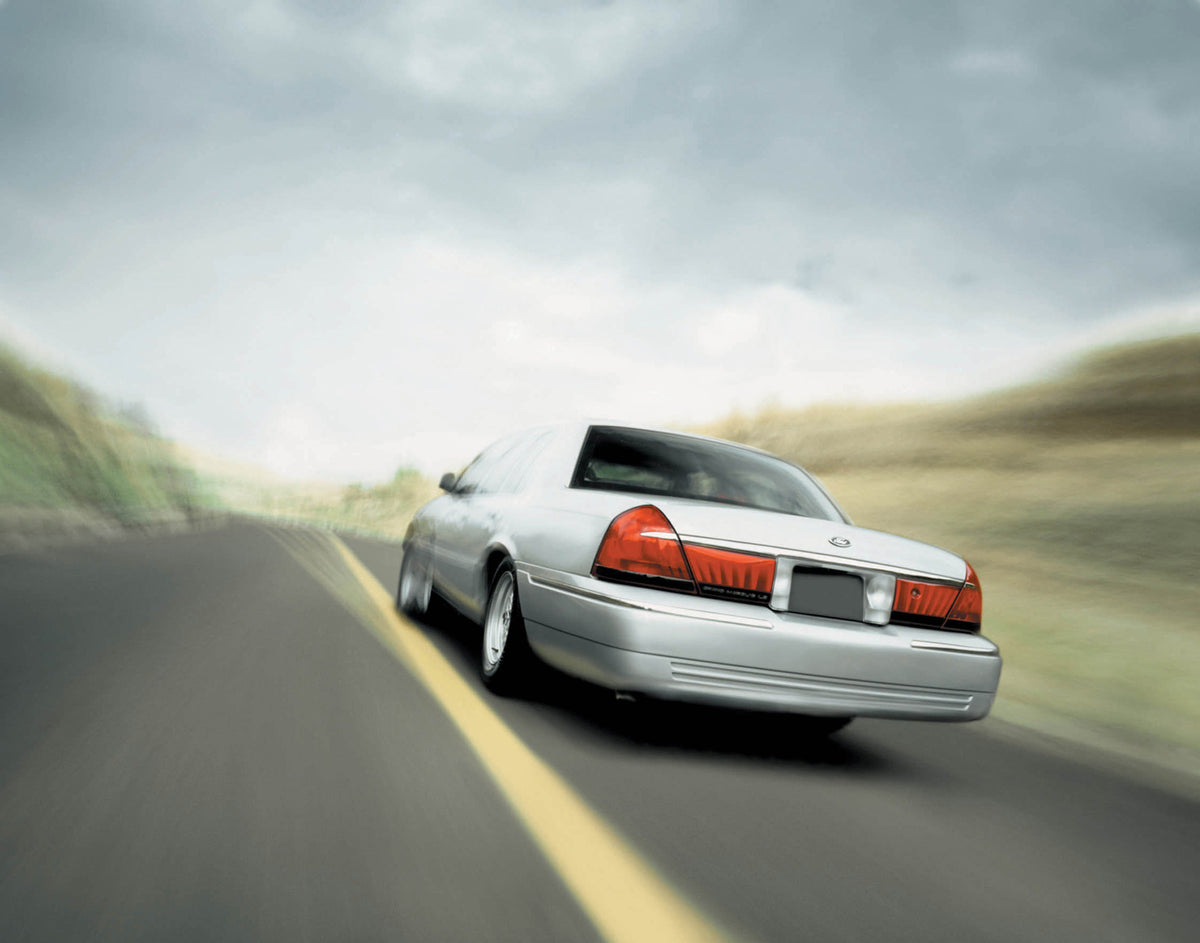 This archival image documents the 2002 Ford Grand Marquis rear view action shot on scenic road MS6693 and is preserved in the Ford Heritage Vault as part of Ford Motor Company's historic photographic archive. Free for personal, non-commercial use....