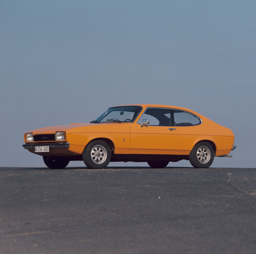 This archival image documents the 1976 Ford Capri II with scenic blue sky and is preserved in the Ford Heritage Vault as part of Ford Motor Company's historic photographic archive. Free for personal, non-commercial use. Ford Heritage Vault referen...