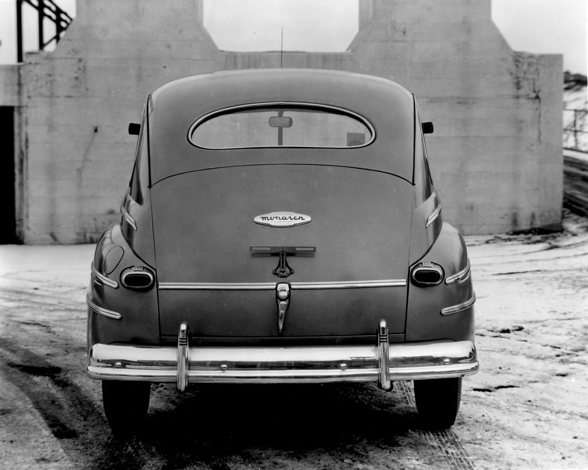 This archival image documents the 1946 Monarch Sedan rear view in front of building AR-2007-5 and is preserved in the Ford Heritage Vault as part of Ford Motor Company's historic photographic archive. Free for personal, non-commercial use. Ford He...