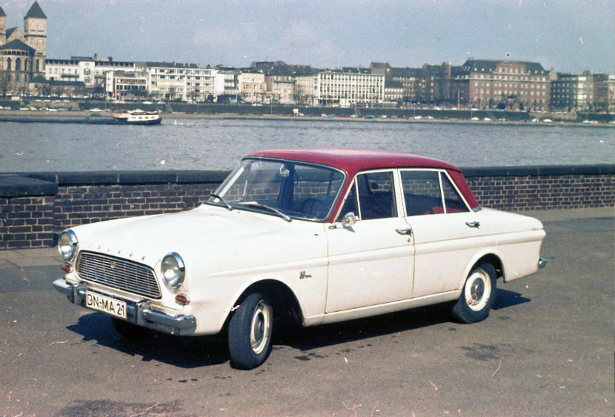This archival image documents the 1962 Ford Taunus 12M P4 on scenic bridge with buildings in distance and is preserved in the Ford Heritage Vault as part of Ford Motor Company's historic photographic archive. Free for personal, non-commercial use....