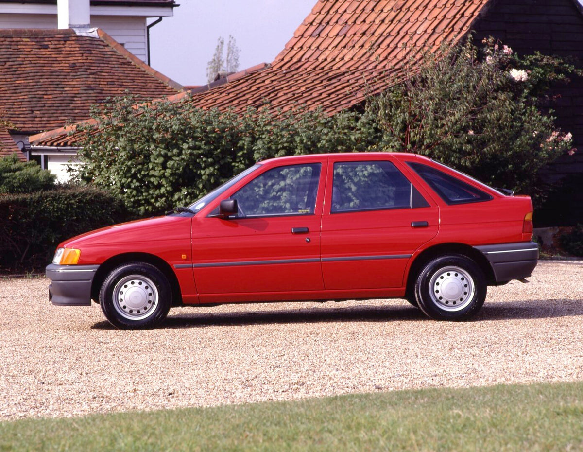 This archival image documents the 1990 Ford Escort Mark V Popular side view on scenic gravel road and is preserved in the Ford Heritage Vault as part of Ford Motor Company's historic photographic archive. Free for personal, non-commercial use. For...