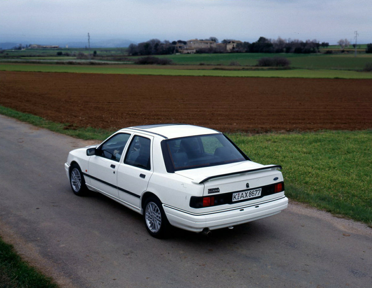 This archival image documents the 1990 Ford Sierra 90.5 LHD rear view on scenic road in Spain and is preserved in the Ford Heritage Vault as part of Ford Motor Company's historic photographic archive. Free for personal, non-commercial use. Ford He...