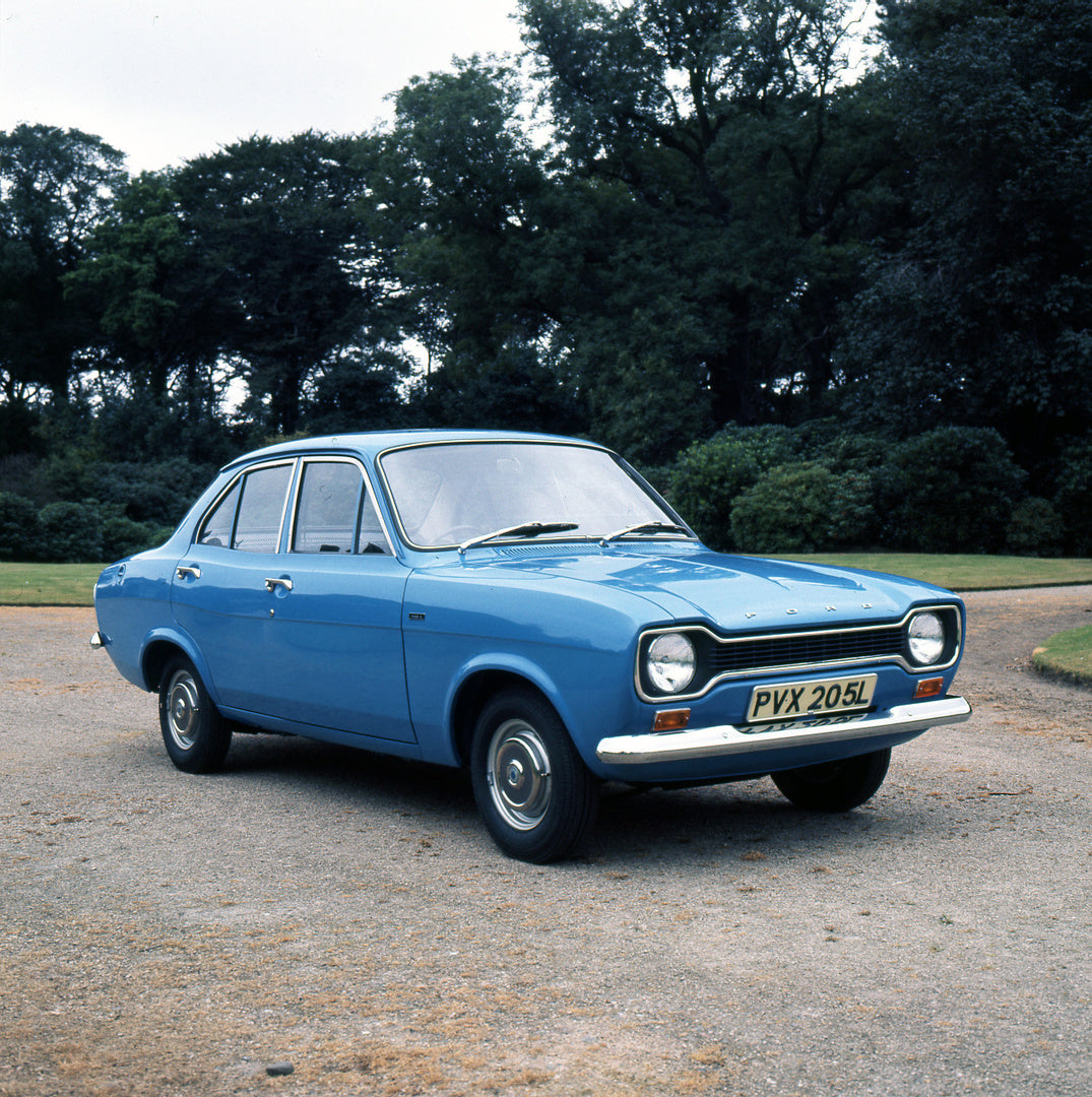 This archival image documents the 1973 Ford Escort Mark I 1100 L 4 Door with scenic trees and is preserved in the Ford Heritage Vault as part of Ford Motor Company's historic photographic archive. Free for personal, non-commercial use. Ford Herita...