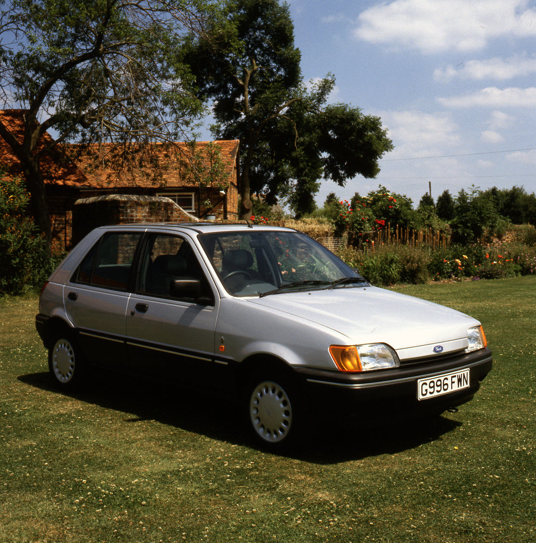 This archival image documents the 1989 Ford Fiesta Mark III Ghia in front of scenic house and is preserved in the Ford Heritage Vault as part of Ford Motor Company's historic photographic archive. Free for personal, non-commercial use. Ford Herita...