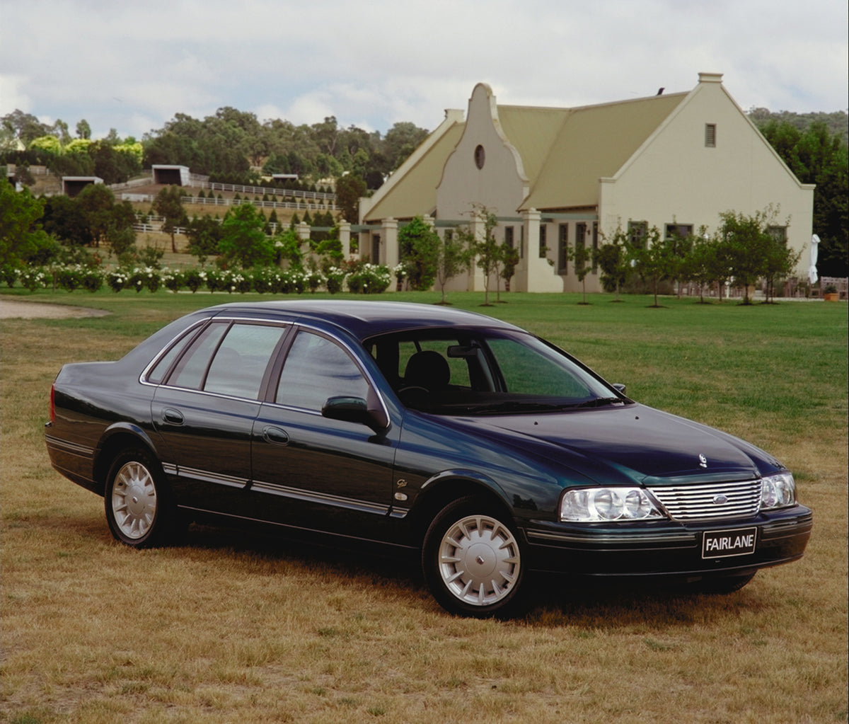 This archival image documents the 1999 Ford Fairlane in field with scenic building and is preserved in the Ford Heritage Vault as part of Ford Motor Company's historic photographic archive. Free for personal, non-commercial use. Ford Heritage Vaul...