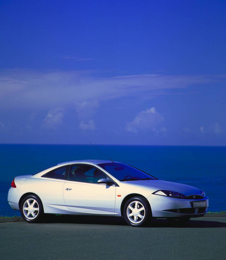 This archival image documents the 1998 Ford Cougar side view near scenic body of water AR-2002-213709 and is preserved in the Ford Heritage Vault as part of Ford Motor Company's historic photographic archive. Free for personal, non-commercial use....